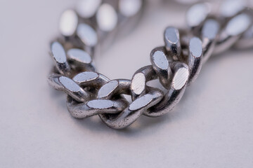 A detailed close‑up of a silver chain on a white background.