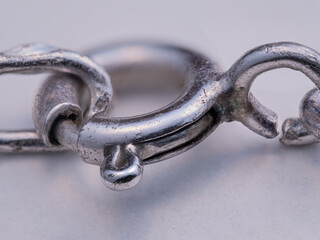 A silver circular chain clasp on a white background.