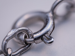 A silver circular chain clasp on a white background.