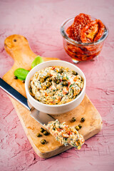 Artisan sun-dried tomato butter - compound butter spread with fresh herbs, dry  tomatos, green pepper and wild garlic served as close-up in a design bowl