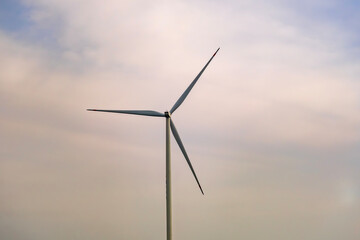 Fototapeta premium a wind turbine, a structure that converts wind energy into electrical energy with rainbow cloudy sky