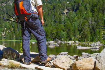 Half-length portrait of a hiker looking at a high mountain lake in the Pyrenees of Catalonia, Spain