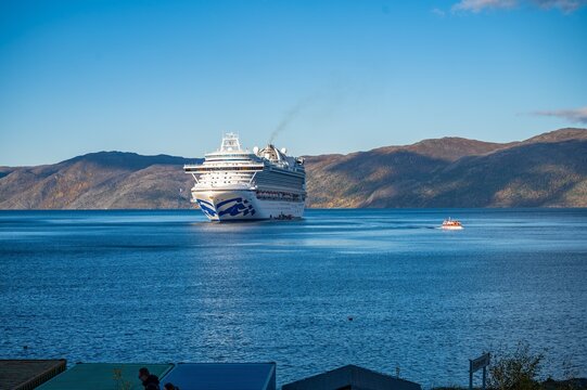 Large Princess Cruises ship anchored in pristine Altafjorden fjord near Alta, Norway. Dramatic Arctic landscape with mountains and calm blue waters. Perfect for travel, tourism and cruise industry mar