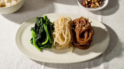 Plate of greens and noodles with sesame in sunlight