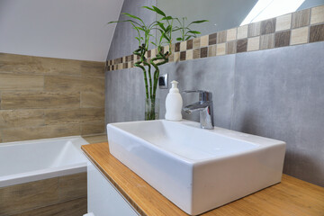 Modern bathroom interior with gray tiles and wooden decors