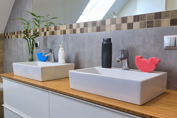 Modern bathroom interior with gray tiles and wooden decors