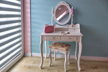 Turquoise girl's room with a dressing table and mirror.
