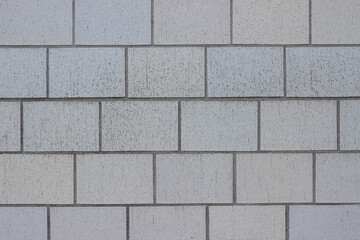 Obraz premium Textured gray concrete block wall with uniform rectangular patterns, showcasing a clean and modern architectural design suitable for various construction applications