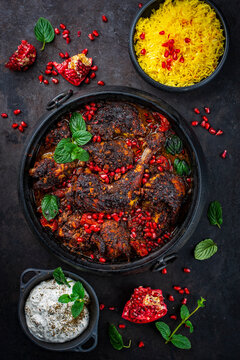 Traditional authentic Persian khoresh fesenjan - chicken stew with walnuts and pomegranate sauce, saffron basmati rice and Mast o Khiar - mint yogurt dip