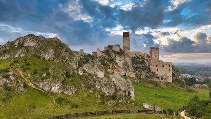 Castle ruins in Olsztyn near Częstochowa captured in golden hour light, aerial drone view over limestone rocks and historic fortress in Poland © Konrad Kerker