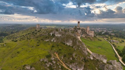 Castle ruins in Olsztyn near Częstochowa captured in golden hour light, aerial drone view over limestone rocks and historic fortress in Poland © Konrad Kerker