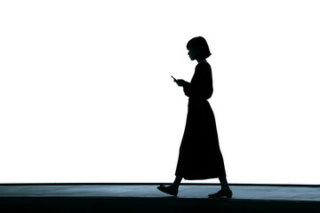 Silhouette of a young Japanese woman walking and using a smartphone against a white background
