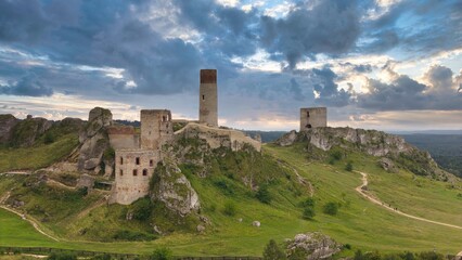 Castle ruins in Olsztyn near Częstochowa captured in golden hour light, aerial drone view over limestone rocks and historic fortress in Poland © Konrad Kerker