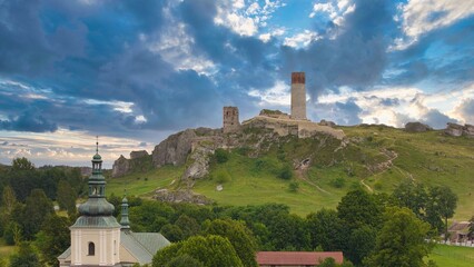 Castle ruins in Olsztyn near Częstochowa captured in golden hour light, aerial drone view over limestone rocks and historic fortress in Poland © Konrad Kerker