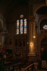 Interior View of a Catholic Church with Stained Glass and Wooden Pews, Cathedral Sanctuary with Ornate Altar and Religious Glass Art, Solemn Church Architecture Featuring Stone Pillars and Chandeliers