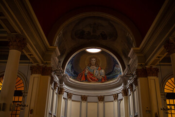Interior of Catholic Church Apse with Mosaic of Jesus Christ, Religious Altar Architecture with Inscription Yo Soy La Vida, Dimly Lit Church Interior with Sacred Mosaic and Crystal Chandeliers