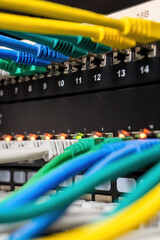 Ethernet cables connecting into a network switch with flashing indicator lights, showing data transfer and communication in a server environment