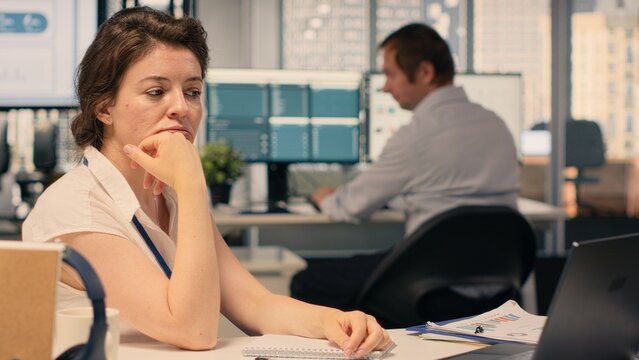 Frustrated businesswoman tearing and crumpling paper after writing mistake at desk. Handwritten notes, ripping pages due to failed attempt and writing error reflect creative block and setback.