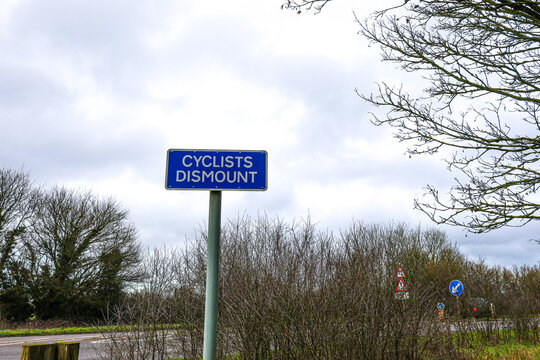 A cyclist dismount sign by the carriageway.  