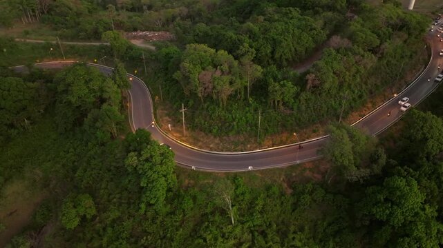 Aerial view of winding road through lush greenery in Thailands countryside
