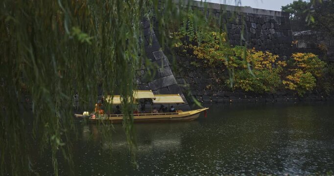 Yellow boat in ancient Japanese moat at it rains - slow motion
