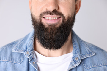 Obraz premium Man with mustache and beard on light grey background, closeup