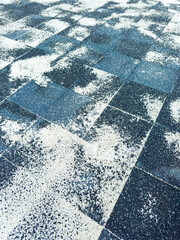 Dirty floor tiles in an outdoor area after rain at a local park in the afternoon on a sunny day with mixed weather