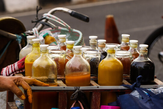 Authentic Jamu Herbal Drink Collection in Vintage Glass Bottles and Traditional Coconut Shell, Indonesian Healthy Turmeric Beverage Gastronomy with Street Vendor and Bamboo Basket Background