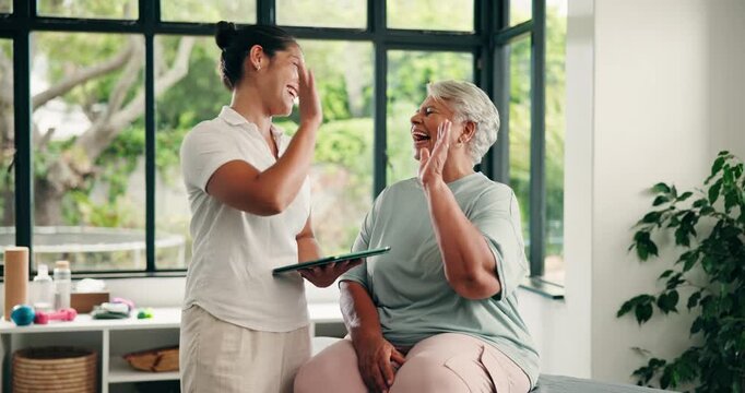 Old woman, physiotherapist and high five with tablet, goals or injury recovery at wellness clinic. Happy people, talk and motivation for rehabilitation, tech and app for elderly patient in retirement