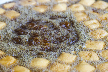 Fototapeta premium Deep Frying Fresh Tofu Dices in Boiling Vegetable Oil with Bubbles and Splashes, Traditional Indonesian Tahu Goreng Cooking Process in Hot Wok, Asian Street Food Gastronomy Production Close Up