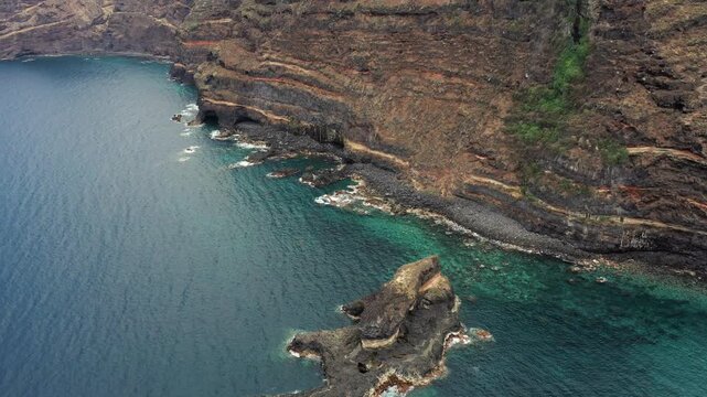 Aerial approach towards Roque El Cagado cliffs and Atlantic coastline in Tenerife