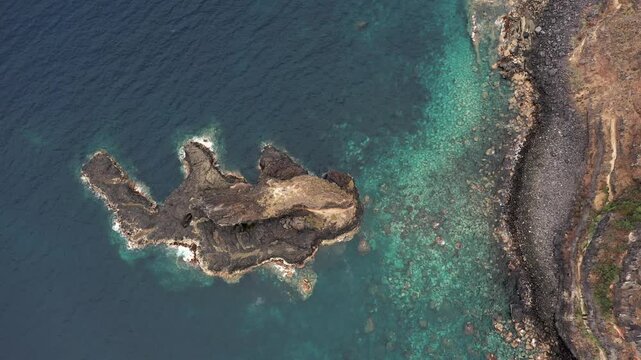 Slow rotating aerial view around Roque El Cagado rock formation and Tenerife cliffs