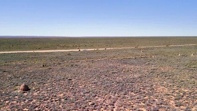 Exmouth road aerial view revealing iconic termite mounds dotting arid outback landscape Western Australia highway