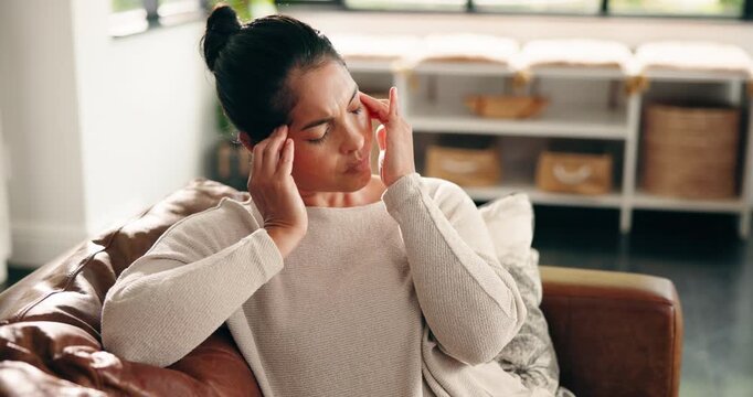 Headache, woman and massage pain on sofa with discomfort, temple pressure and mental fatigue. Stress, person and tension migraine in home with burnout, brain fog and overwhelmed by uncomfortable ache