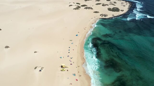 Aerial drone flight over Corralejo dunes and beach rising to reveal Atlantic Ocean and Isla de Lobos in the distance