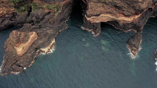 Aerial drone approach to Roque El Cagado cliffs with camera tilt from top-down to forward view in Tenerife