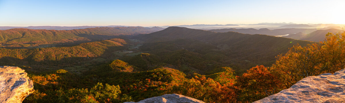 Sunrise at McAfee Knob on the Appalachian Trail looking down into the valley with green and orange leaves