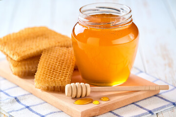 nature honey in a jar on a white wooden table, selective focus.