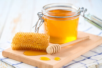 jar of nature honey on light kitchen table, selective focus. Honey in a glass jar.