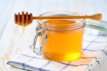 nature honey in a jar on a white wooden table, selective focus. Jar of sweet honey .