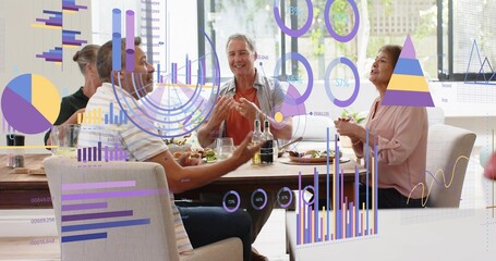 Chatting group of four adults sharing meal around wooden table by large windows with charts