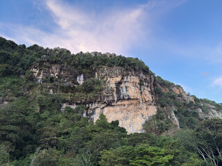  Limestone mountain face with tropical vegetation at sunset