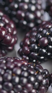 Detailed photograph of luscious blackberries highlighting texture, Studiolit macro photography capturing essence of ripe blackberries and their natural glossiness