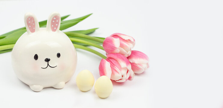 Cute Easter Bunny Figure with Eggs and Pink Tulips on White Background
