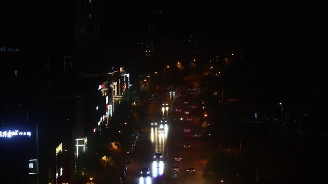 Night Traffic on Illuminated Urban Road with City Lights