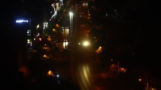 Night Traffic on Mountain Road with City Lights