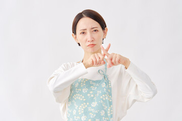 エプロンをつけた女性　ばつ印のジェスチャー　白背景
