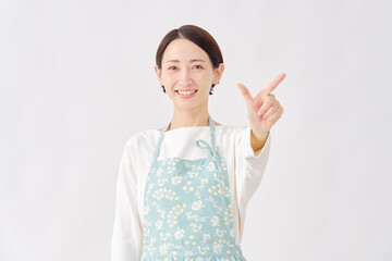 エプロンをつけた女性　チェックサインのジェスチャー　白背景