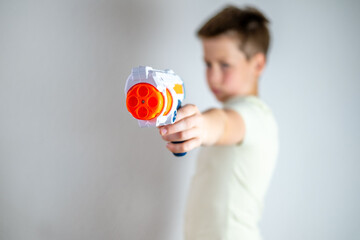 toy gun, with young boy holding in background, military toys prop, aggression and impact on young minds, parenting and behavioral development © kittyfly