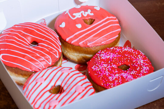 Donas con glaseado de fresa y decoraci&oacute;n por el d&iacute;a del amor.